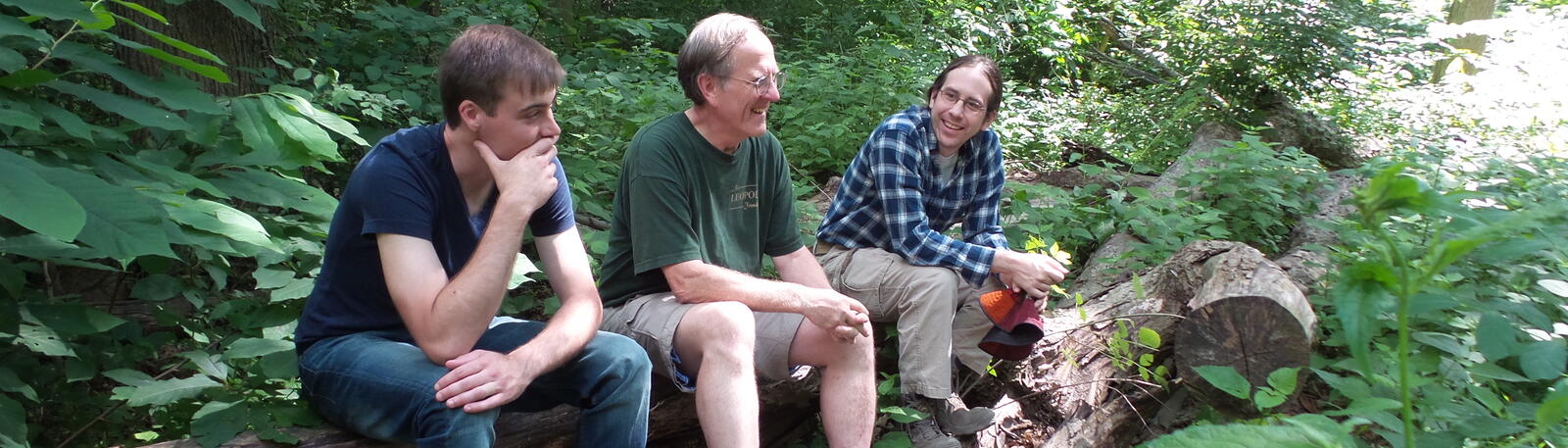 photo of students and a professor in the woods