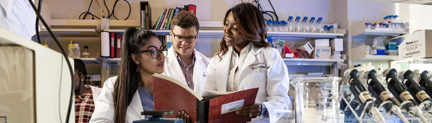 photo of students and a professor in a lab