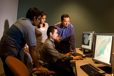 photo of students and a faculty member working on a project